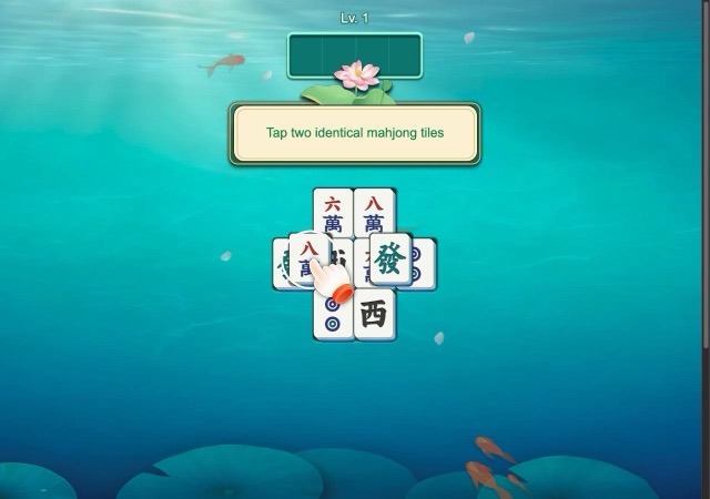 Level 1 mahjong board with tutorial hint and pointing hand over underwater koi pond